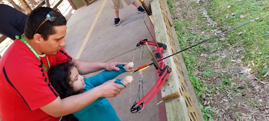 father teaching daughter archery