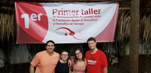 louis, elizabeth, ashley, and bryce in front of the banner