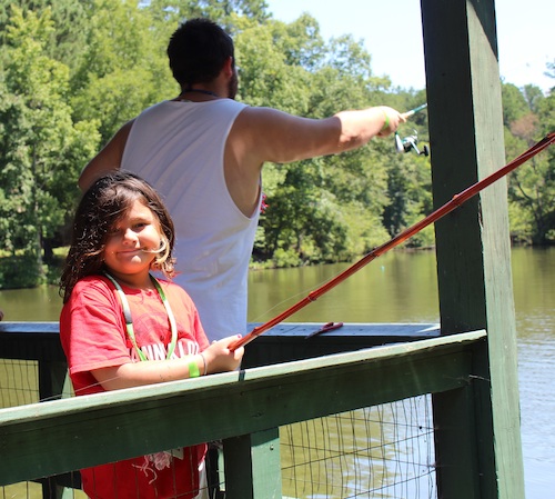 Girl and counselor fishing on a dock