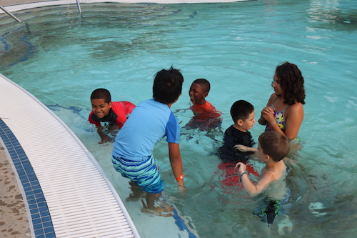 group of kids in pool learning to swim