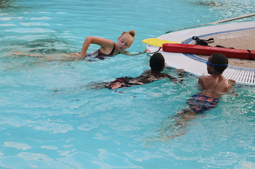 group of kids in pool learning to swim