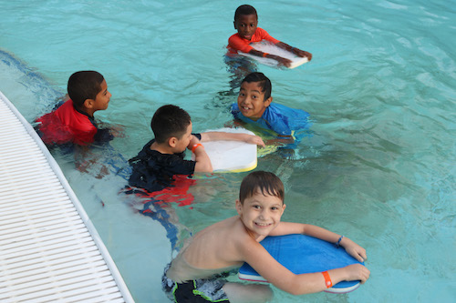 group of kids in pool learning to swim