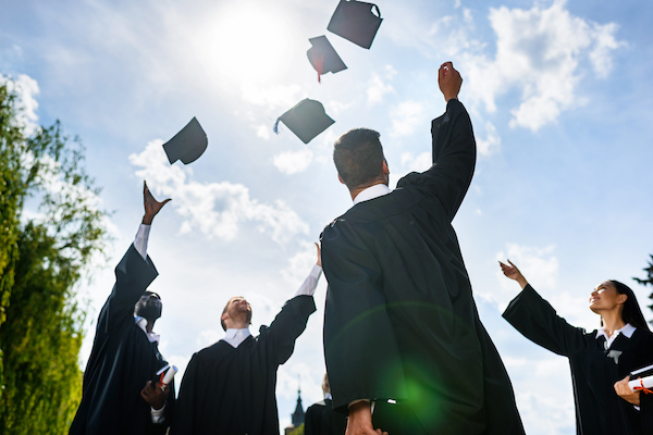 Graduates tossing caps in air