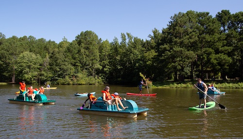 people paddle boating at a lake