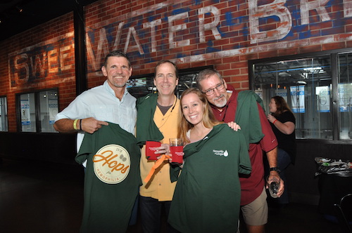 Group photo in front of brewery logo