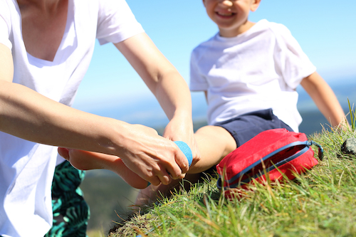 first aid being applied to a boys knee