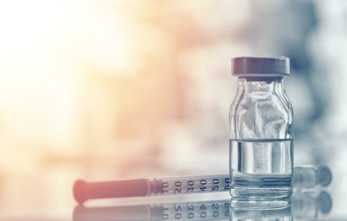 Medicine bottle and needle on desk